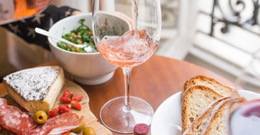 Gedeckter Tisch mit Wein, Käse und Brot